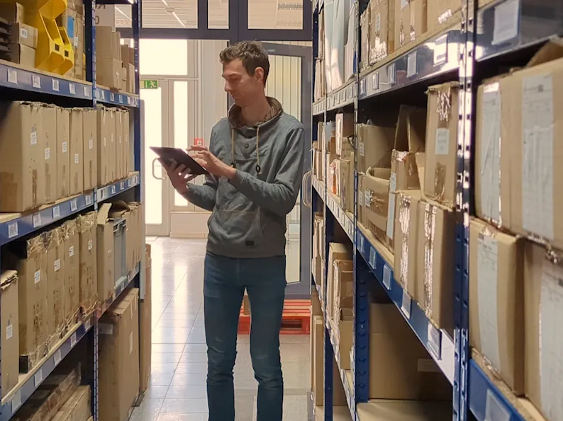 Person in der Fertigung mit Tablet zur digitalen Prozessoptimierung