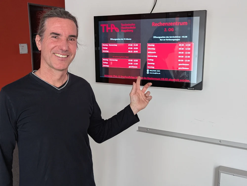 Jürgen Werner vor einem digitalen Display an der TH Augsburg
